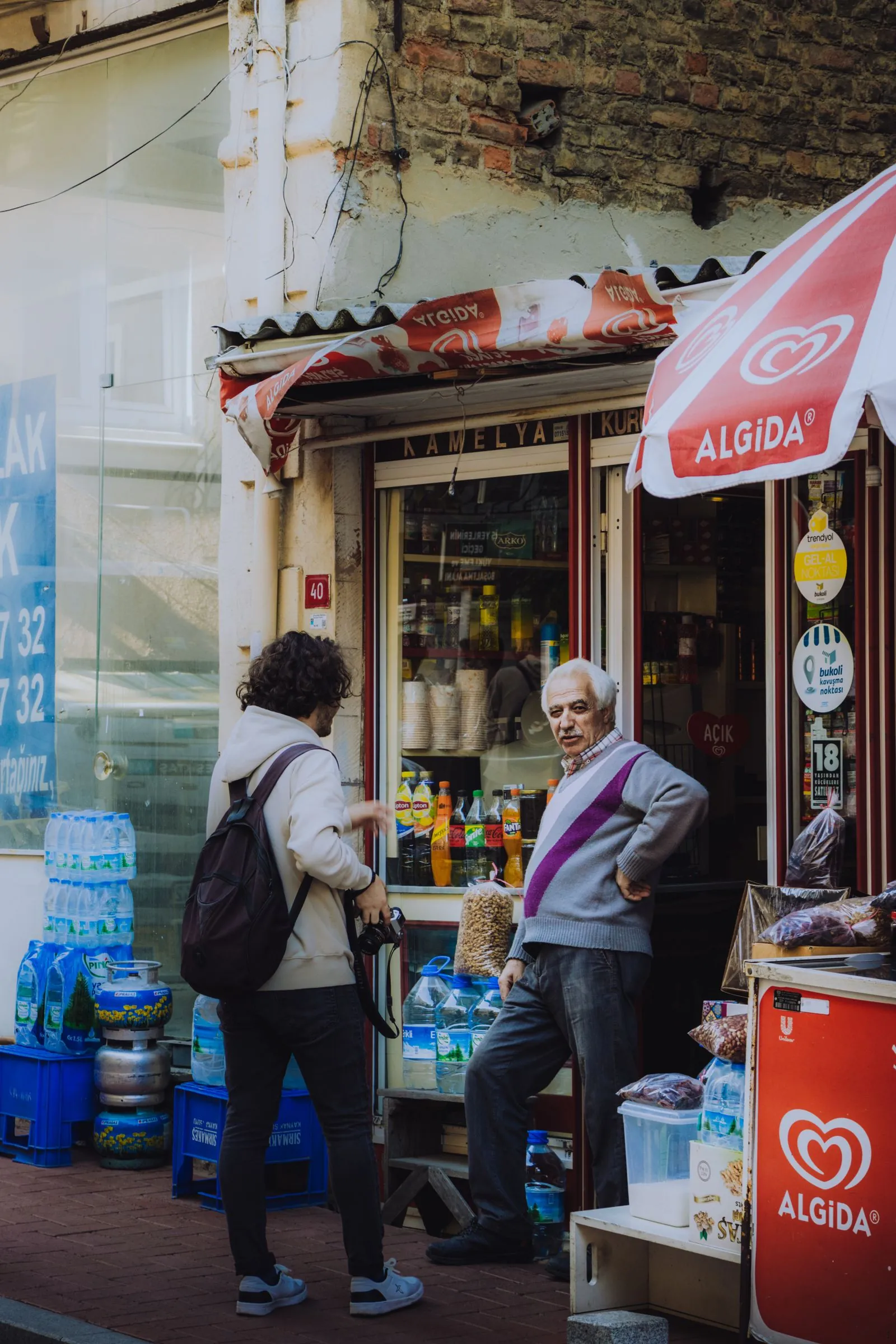 Two people talk outside a local shop.