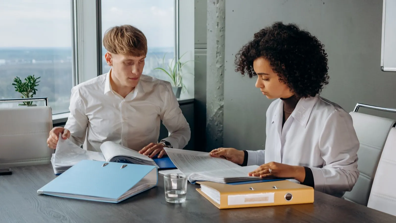 Two colleagues study a financial report together.